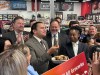 Manitoba Premier Wab Kinew eats rotisserie chicken at a news conference inside a grocery store in Winnipeg, on Wednesday, March 25, 2026. Kinew was promoting his government's plan to remove the provincial sales tax from all food in grocery stores. THE CANADIAN PRESS/Steve Lambert