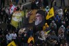 A Hezbollah supporter waves a flag with the portrait of the late Hezbollah leader Sayyed Hassan Nasrallah during a protest against the Lebanese Prime Minister Nawaf Salam, in front the government palace in Beirut, Lebanon, Friday, April 10, 2026. (AP Photo/Hussein Malla)