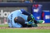 Toronto Blue Jays designated hitter George Springer falls to the ground after taking a foul ball of his foot while playing against he Minnesota Twins during third inning American League MLB baseball action in Toronto on Saturday, April 11, 2026. THE CANADIAN PRESS/Nathan Denette