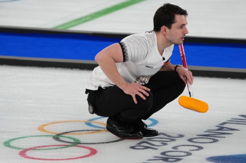 Switzerland's Benoit Schwarz-van Berkel competes during a men's curling bronze medal match between Norway and Switzerland, at the 2026 Winter Olympics, in Cortina d'Ampezzo, Italy, Friday, Feb. 20, 2026. (AP Photo/Misper Apawu)