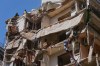 Workers remove the rubble as rescuers keep searching for a missing woman and girl at a destroyed building that was hit on April 8, in an Israeli airstrike in Beirut, Lebanon, Monday, April 13, 2026. (AP Photo/Hussein Malla)