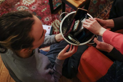 Guests collect their smartphones at the end of a weekly phone-free gathering at the home of organizer Dan Fox in the Brooklyn borough of New York, Wednesday, March 25, 2026. (AP Photo/Heather Khalifa)