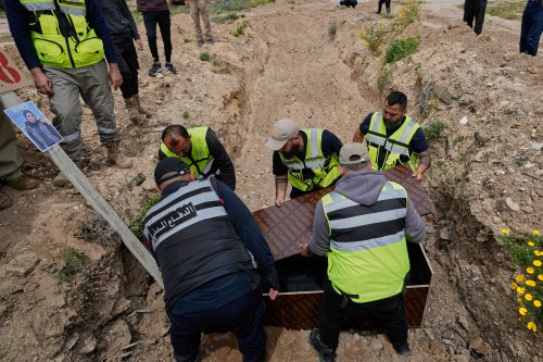 Paramedics bury the body of Ghadir Baalbaki, 19, who was killed on Tuesday in an Israeli airstrike, at a temporary mass grave in the southern port city of Tyre, Lebanon, Wednesday, April 15, 2026. (AP Photo/Hussein Malla)