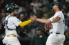 Athletics pitcher Joel Kuhnel, right, shakes hands with Shea Langeliers after the Athletics victory over the Texas Rangers in a baseball game Wednesday, April 15, 2026, in West Sacramento, Calif. (AP Photo/Scott Marshall)