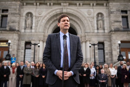 Premier David Eby is joined by fellow MLAs in solidarity as he speaks during a press conference on Thursday, Feb. 12, 2026. THE CANADIAN PRESS/Chad Hipolito