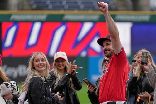 Cleveland Guardians catcher Austin Hedges, right, gestures after proposing to Lexi Dickinson, left, after a baseball game against the Baltimore Orioles in Cleveland, Sunday, April 19, 2026. (AP Photo/Sue Ogrocki)