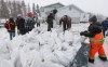 Sandbags are unloaded at a home at Peguis First Nation, Man., on Thursday, April 16, 2026. THE CANADIAN PRESS/John Woods