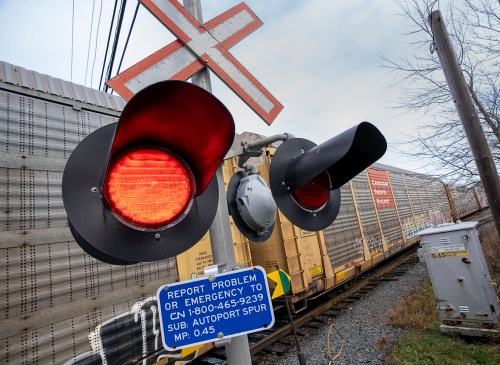 Level crossing signals flash as a CN Rail train passes in Dartmouth, N.S. on Thursday, Nov. 25, 2021. THE CANADIAN PRESS/Andrew Vaughan