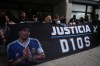 Fans of the late soccer star Diego Maradona stand outside court on the first day of the trial of his medical team for alleged homicide by negligence in San Isidro, Argentina, Tuesday, April 14, 2026. (AP Photo/Rodrigo Abd)
