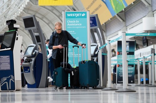 Passengers are seen in the WestJet check-in area at Pearson International Airport, in Toronto, Saturday, June 29, 2024. THE CANADIAN PRESS/Christopher Katsarov”