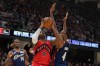 Toronto Raptors forward RJ Barrett (9) goes to the basket between Cleveland Cavaliers guard Keon Ellis (14) and centre Evan Mobley (4) in the first half in Game 2 of a first-round NBA basketball playoffs series in Cleveland, Monday, April 20, 2026. (AP Photo/Sue Ogrocki)