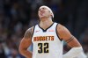 Denver Nuggets forward Aaron Gordon holds his back after taking a hit in the second half in Game 1 of a first-round NBA playoffs basketball series against the Minnesota Timberwolves, Saturday, April 18, 2026, in Denver. (AP Photo/David Zalubowski)