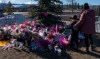 A mother and son pay their respects at a memorial for the victims of a mass shooting in Tumbler Ridge, B.C., Saturday, Feb. 14, 2026. THE CANADIAN PRESS/Christinne Muschi