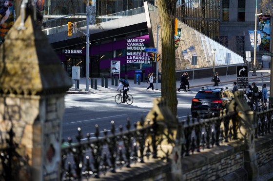 People make their way past the Bank of Canada building in downtown Ottawa on Tuesday. (Sean Kilpatrick / The Canadian Press)
