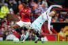 Manchester United's Kobbie Mainoo, left, and Brentford's Mikkel Damsgaard fight for the ball during the Premier League soccer match between Manchester United and Brentford in Manchester, England, Monday, April 27, 2026. (AP Photo/Dave Thompson)