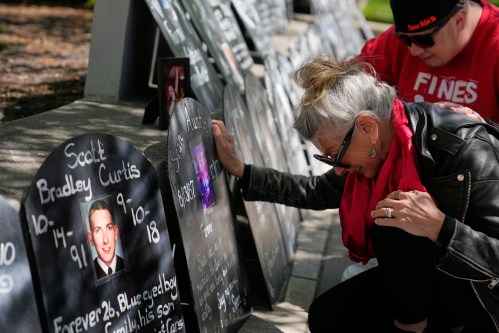 Tanny Austin cries while looking at tombstones with the names of victims of the opioid crisis, including her son Sean Austin, during a rally outside of a courthouse in Newark, N.J., Tuesday, April 21, 2026. (AP Photo/Seth Wenig)