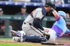 Atlanta Braves catcher Jonah Heim, front, tries to field the throw as Colorado Rockies' TJ Rumfield scores on a ground out by Willi Castro in the first inning of a baseball game Friday, May 1, 2026, in Denver. (AP Photo/David Zalubowski)