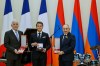 In this photo distributed by the Armenian Prime Minister Press Office, Armenian President Vahagn Khachaturyan, left, French President Emmanuel Macron, center, and Armenian Prime Minister Nikol Pashinyan hold awards following a state dinner after the European Political Community in Yerevan, Armenia, Monday, May 4, 2026. (Tigran Mehrabyan/Armenian Prime Minister Press Office via AP)