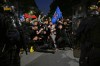 PSG supporters face French riot police as they celebrate Paris Saint-Germain's Champions League semifinal victory over Bayern Munich at Place de la Concorde in Paris, Thursday, May 7, 2026. (AP Photo/Emma Da Silva)