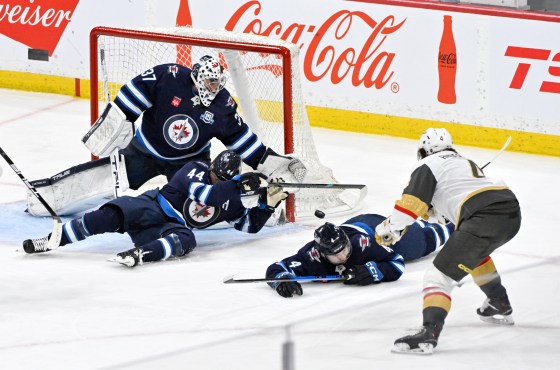 Winnipeg Jets' Josh Morrissey (44) and Neal Pionk (4) slide to block a shot on goaltender Connor Hellebuyck (37) by Vegas Golden Knights' Rasmus Andersson (4) during the teams' last matchup March 24. (Fred Greenslade / The Canadian Press files)