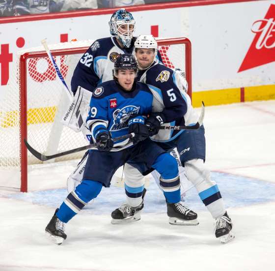 Manitoba Moose centre Brayden Yager (No. 29) fights for his position in the slot against Admirals defenceman Kevin Gravel, while Admirals goaltender Matthew Murray (No. 32) keeps an eye on the play during Friday's game. (Brook Jones / Free Press files)