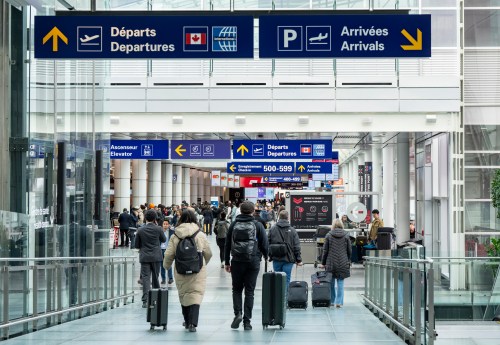 Travellers are seen walking at Montreal-Pierre Elliott Trudeau International Airport in Montreal on Wednesday, March 18, 2026. THE CANADIAN PRESS/Christinne Muschi