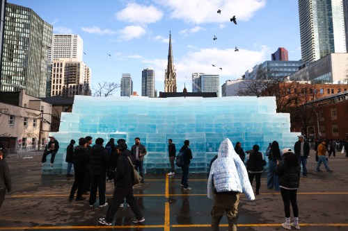 People gather around blocks of ice, installed in a Toronto parking lot as part of promotion for rapper Drake's upcoming album 'ICEMAN' on Monday, April 20, 2026. THE CANADIAN PRESS/Cole Burston