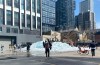 People gather around and climb blocks of melting ice, installed in a Toronto parking lot as part of a promotion for rapper Drake's upcoming album 'ICEMAN' on Thursday, April 23, 2026. Toronto police say people climbing and playing in the ice blocks of the Drake's 