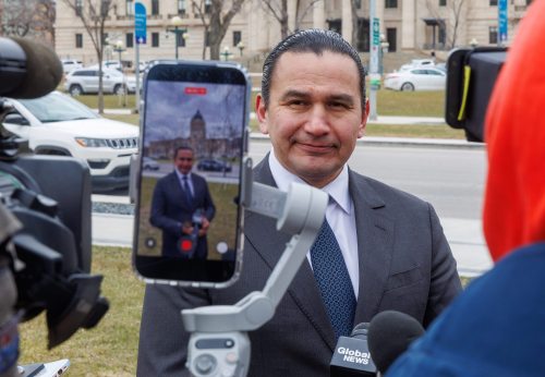 MIKE DEAL / FREE PRESS
Premier Wab Kinew’s social media staff use an iPhone to capture his scrum with the media after speaking at the National Day of Mourning event at the Workers Memorial in Memorial Park on Tuesday. 
260428 - Tuesday, April 28, 2026.