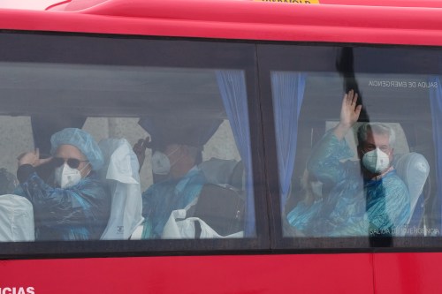 Passengers wave inside a bus after being disembarked from the hantavirus-stricken cruise ship MV Hondius at the port of Granadilla in Tenerife, Canary Islands, Spain, Sunday, May 10, 2026. THE CANADIAN PRESS/AP-Manu Fernandez