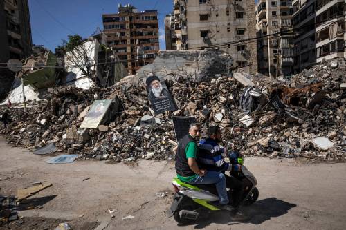 The New York Times / File
                                Men pass a poster of Ayatollah Ali Khamenei, the late supreme leader of Iran, on a pile of rubble from Israeli airstrikes.