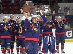 Marlen Edwards lifts the Centennial Cup into the air after helping the Niverville Nighthawks to a national championship. (Cassidy Dankochik / The Carillon)