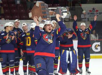 Marlen Edwards lifts the Centennial Cup into the air after helping the Niverville Nighthawks to a national championship. (Cassidy Dankochik / The Carillon)