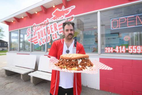 Mike Sudoma/Free Press 
                                St. James Burger and Chip Co. owner Kevin Ramberran shows off the World&rsquo;s Largest Fat-Boy in front of his restaurant.