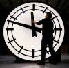 **FILE** An electric Time machinist prepares to remove the hands of an eight-foot clock in this March 2007 file photo in Medfield Mass. After clocks are turned back this weekend, pedestrians walking during the evening rush hour are nearly three times more likely to be struck and killed by cars than before the time change, two scientists calculate. (AP Photo/Stephan Savoia, FILE)