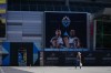A pedestrian walks past a FIFA World Cup countdown timer and an advertisement with photographs of Vancouver Whitecaps MLS soccer players Thomas Muller, Brian White, Sam Adekugbe, Andres Cubas and Ryan Gauld outside B.C. Place stadium, in Vancouver, on Monday, May 4, 2026. THE CANADIAN PRESS/Darryl Dyck