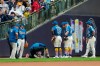 Milwaukee Brewers' Brandon Lockridge is looked at by a trainer after suffering an injury during the fourth inning of a baseball game against the New York Yankees, Friday, May 8, 2026, in Milwaukee. (AP Photo/Aaron Gash)