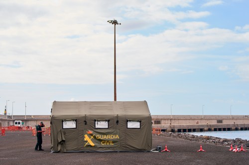 A Spanish Civil Guard officer inspects the area where passengers from the MV Hondius cruise ship are expected to arrive at the port of Granadilla in Tenerife, Canary Islands, Spain, Saturday, May 9, 2026. (AP Photo/Manu Fernandez)