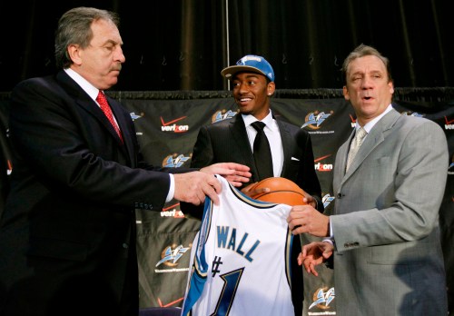 FILE - Washington Wizards first draft pick John Wall, center, from the University of Kentucky, smiles as he holds up a ball and jersey with coach Flip Saunders, right, and Wizards president Ernie Grunfeld, during a news conference in Washington, June 25, 2010. (AP Photo/Alex Brandon, File)