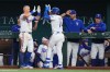 Texas Rangers' Justin Foscue, center right, is greeted by Josh Jung near the dugout after hitting his first career home run during the third inning of a baseball game against the Chicago Cubs, Saturday, May 9, 2026, in Arlington, Texas. (AP Photo/Julio Cortez)