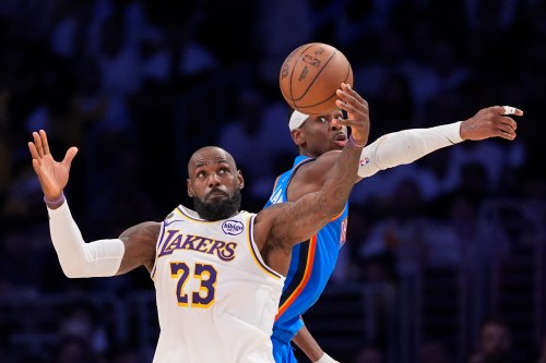 Los Angeles Lakers forward LeBron James, left, takes a pass as Oklahoma City Thunder guard Shai Gilgeous-Alexander defends during the first half of Game 3 in a second-round NBA basketball playoffs series Saturday, May 9, 2026, in Los Angeles. (AP Photo/Mark J. Terrill)