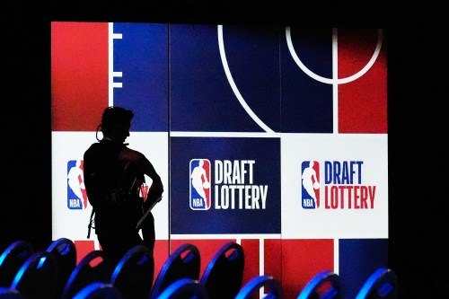 A person walks by a sign in the NBA basketball draft lottery in Chicago, Sunday, May 10, 2026. (AP Photo/Nam Y. Huh)