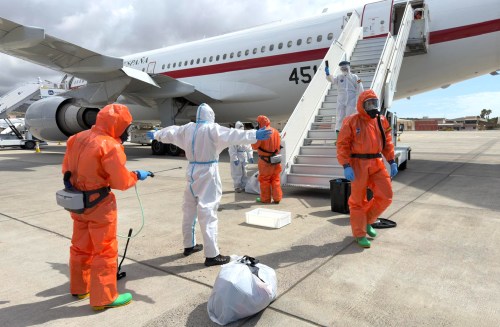 A Spanish passenger is sprayed with disinfectant by Spanish government officials before boarding a plane after disembarking from the hantavirus-stricken cruise ship MV Hondius at Tenerife airport in the Canary Islands, Spain, Sunday, May 10, 2026. (AP Photo)