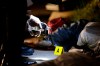 FILE - Policemen check the gun recovered from one of two unidentified drug suspects after they were shot dead by police while trying to evade a checkpoint in Quezon city, north of Manila, Philippines, Sept. 6, 2016. (AP Photo/Aaron Favila, File)