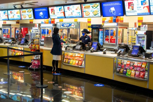 A movie goer stands at the concessions kiosk in the lobby of a Cineplex theatre in Toronto, on Tuesday, Oct. 6, 2020. THE CANADIAN PRESS/Chris Young