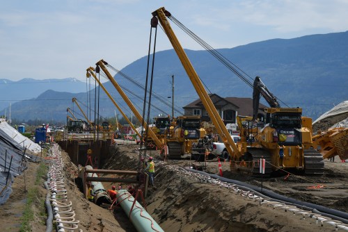 Workers lay pipe during construction of the Trans Mountain pipeline expansion on farmland, in Abbotsford, B.C., on Wednesday, May 3, 2023. THE CANADIAN PRESS/Darryl Dyck