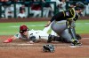 Arizona Diamondbacks' Alek Thomas, left, scores a run as Pittsburgh Pirates catcher Joey Bart makes a late tag during the sixth inning of a baseball game, Tuesday, May 5, 2026, in Phoenix. (AP Photo/Ross D. Franklin)