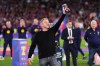 Barcelona head coach Hansi Flick lifts his award to the sky celebrating after defeating Real Madrid 2-0 to win the Spanish La Liga soccer championship with three rounds to spare, in Barcelona, Spain, Sunday, May 10, 2026. (AP Photo/Joan Mateu Parra)