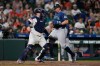 Seattle Mariners' Cal Raleigh scores behind Houston Astros catcher Christian Vázquez during the seventh inning of a baseball game Tuesday, May 12, 2026, in Houston. (AP Photo/David J. Phillip)