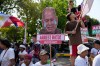 A protester carries a slogan with a photo of Philippine Senator Ronald dela Rosa crying during a rally outside the Philippine Senate in Pasay, Philippines on Wednesday, May 13, 2026. (AP Photo/Aaron Favila)